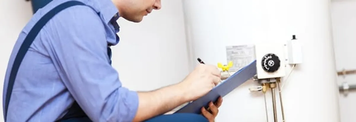 Water heater repair technician inspecting the unit and recording service notes in Providence, RI